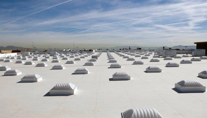 Industrial building roof coated with Super Therm ceramic thermal barrier reflecting solar heat and dramatically reducing HVAC costs